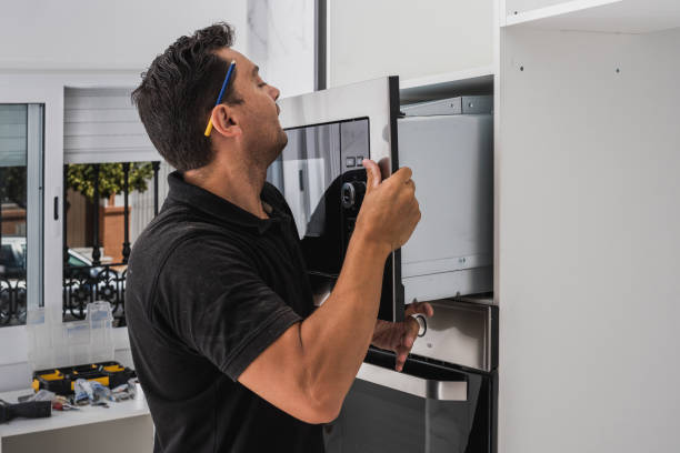 istock Man placing a microwave inside the hole of a new kitchen cabinet 1334502210