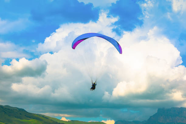 istock Blue paraglider on the background of beautiful clouds 1334504693