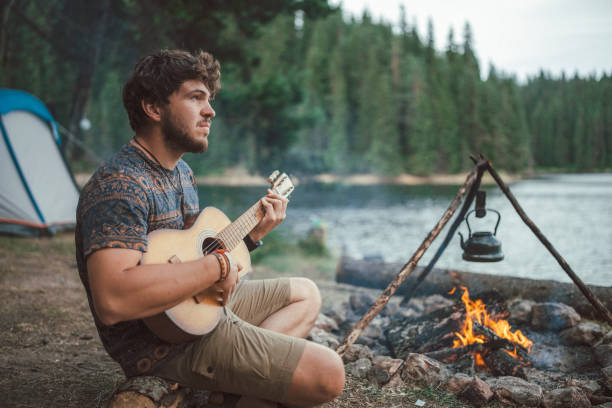 istock Young man playing the guitar on camping 1334504884