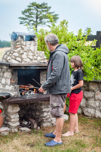 istock Father and son cooking meat on barbecue grill 1334507387