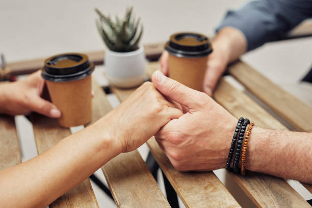 istock Couple Holding Hands in Cafe 1334507645