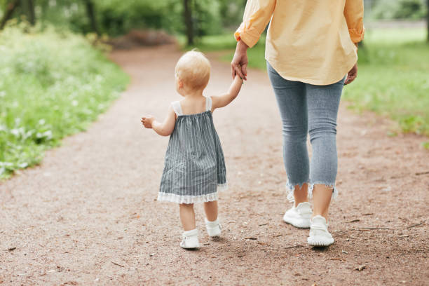 istock Baby Girl Walking with Mom 1334507980