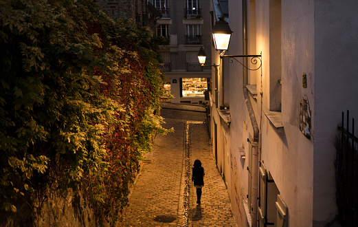 Street lit alleyway at night in Montmarte, Paris.