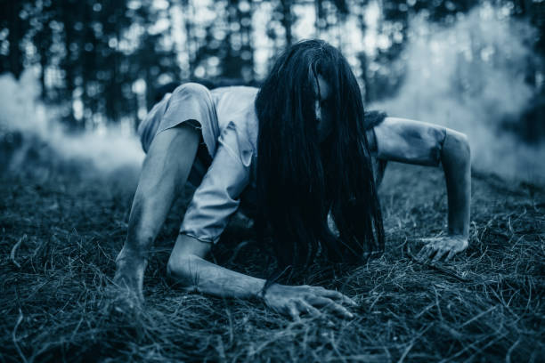 ragazza nell'immagine di zombie spaventosi striscia a terra nella foresta oscura. - vengeful foto e immagini stock