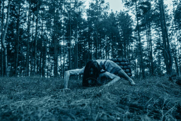 ragazza nell'immagine di zombie spaventosi striscia a terra nella foresta oscura. - vengeful foto e immagini stock