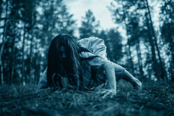 girl in image of scary zombie crawls on ground in dark forest. - vengeful imagens e fotografias de stock