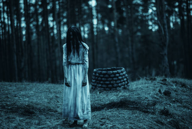 girl in image of scary zombie walks in dark forest near stone well. - vengeful imagens e fotografias de stock