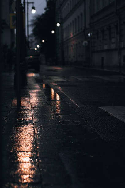 istock Dark evening street after rain with reflection in puddles 1334519786