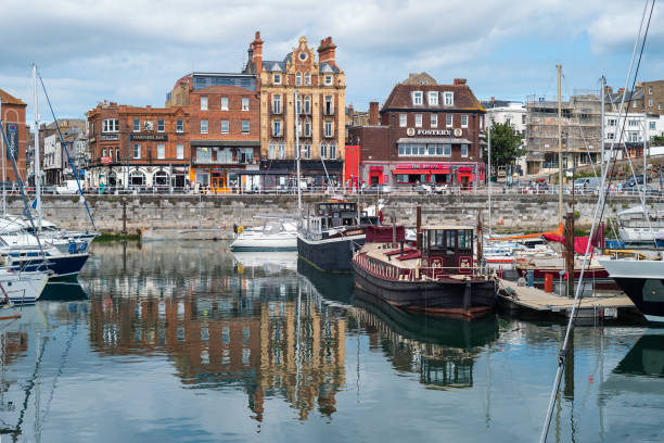Ramsgate Royal Harbour with waterside impressive architecture reflecting in the harbour basin alongside a collection of boats and yachts. Ramsgate, UK - Aug 14 2021 Ramsgate Royal Harbour with waterside impressive architecture reflecting in the harbour basin alongside a collection of boats and yachts. isle of thanet photos stock pictures, royalty-free photos & images