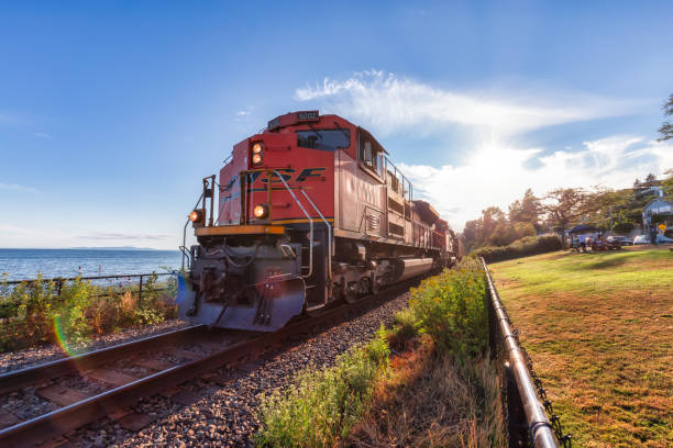 White Rock, Greater Vancouver, British Columbia, Canada - July 25, 2021: A freight train riding through the city by the beach during a colorful summer evening.