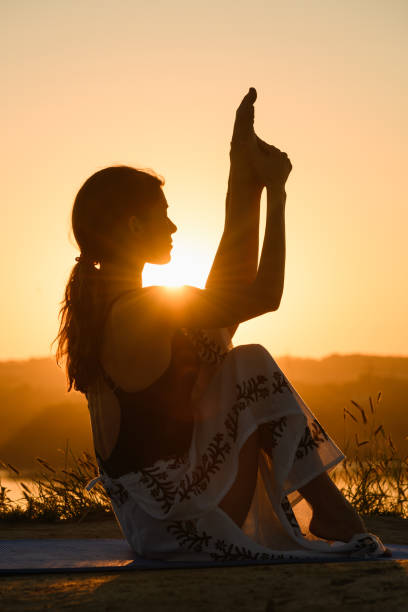 istock Female silhouette stretching at warm sun light 1334522664