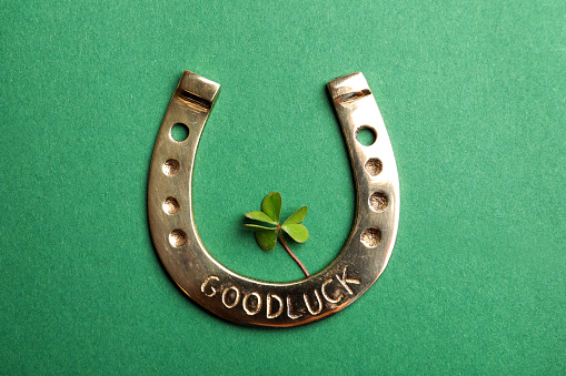 Flat lay composition with horseshoe on green background. St. Patrick's Day celebration