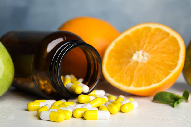 Bottle with vitamin pills and fruits on white table, closeup Bottle with vitamin pills and fruits on white table, closeup brain jar stock pictures, royalty-free photos & images
