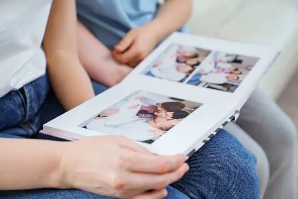 top view. mother and daughter watch photobook from discharge of newborn baby.family tradition of printing photos and looking at them with children and remembering.photographer and designer