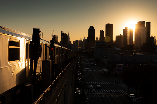Elevated subway train during sunset in Queens, New York City.