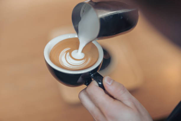 istock Female hands decorating coffee with milk and making latte art 1334531040