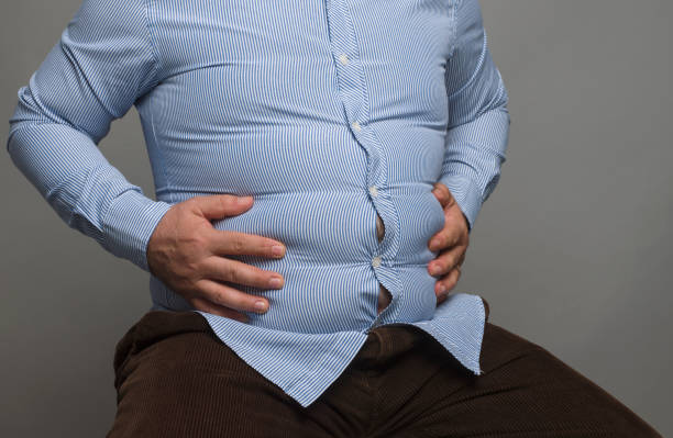 Mid section of an overweight man, studio shot stock photo
