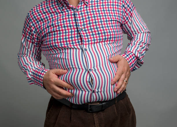 istock Mid section of an overweight man, studio shot 1334535154