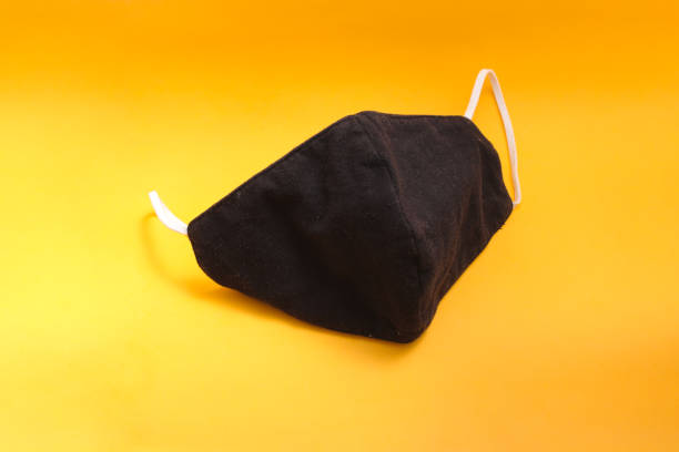 istock Reusable black cloth mask on orange background 1334535176