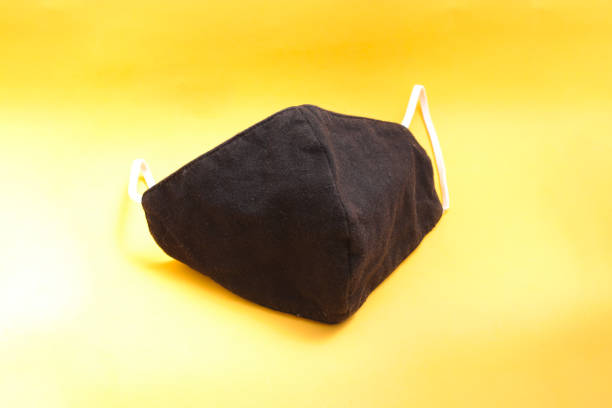 istock Reusable black cloth mask on orange background 1334535748