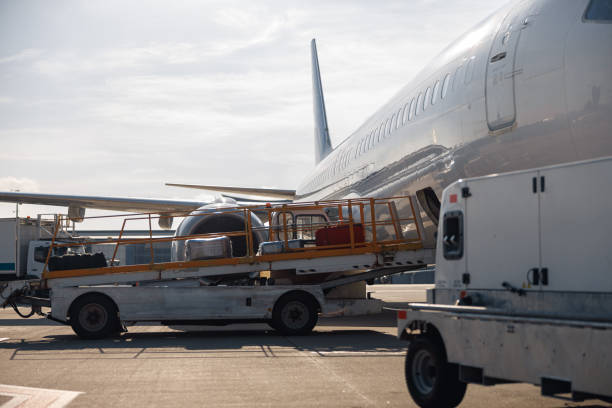 istock Baggage on conveyor belt unloaded from an airplane outdoors on a daytime 1334536131