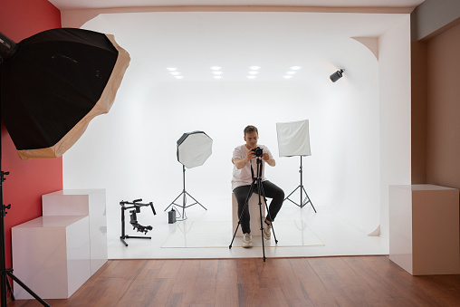 Portrait of photographer taking pictures in studio.