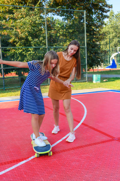 istock A Mother is Teaching her Daughter to Ride the Skateboard. 1334540583