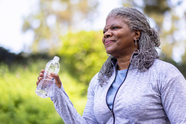 istock Senior black woman drinking water during workout 1334542091