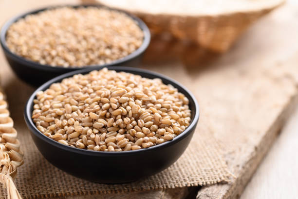 istock Wheat grain in a black bowl on wooden 1334553386
