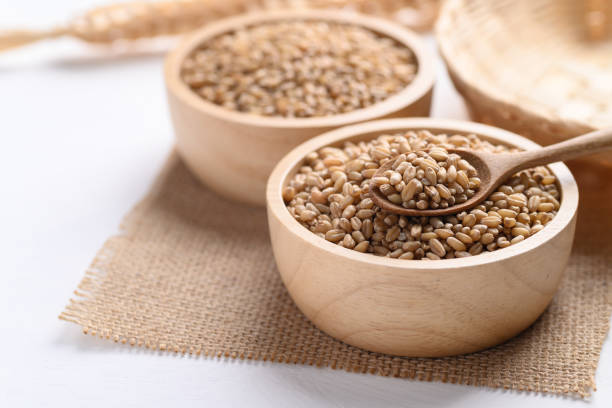 istock Wheat grain in a wooden bowl with spoon 1334553387