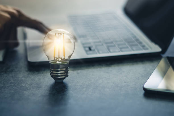 istock Bright light bulb with laptop and book. Business and education concept 1334553619