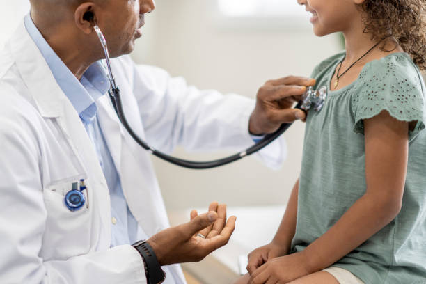 Doctor using a stethoscope to examine a young girl's chest A concept photo showing a doctor using a stethoscope to examine a young child's chest. obscured face stock pictures, royalty-free photos & images