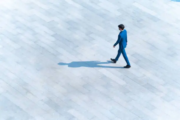 Photo of top aerial view businessman people walk on across pedestrian concrete with black silhouette shadow on ground, concept of social still life.