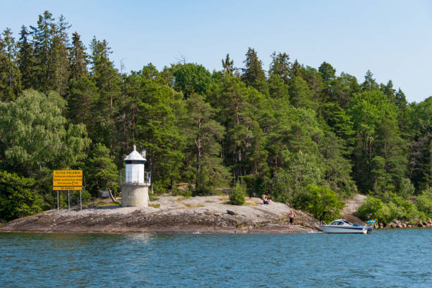 Stockholm, Sweden Stockholm, Sweden July 16, 2021 A small lighthouse on Lake Malaren and a small boat, and a sign in Swedish and English says Water protection area. lake malaren photos stock pictures, royalty-free photos & images