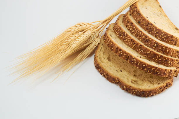 istock Sliced whole wheat bread on white background, wheat leaves for cutting out. 1334559361