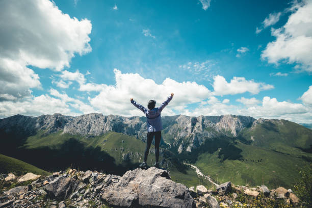 istock Successful woman hiking on sunset alpine mountain peak 1334563621