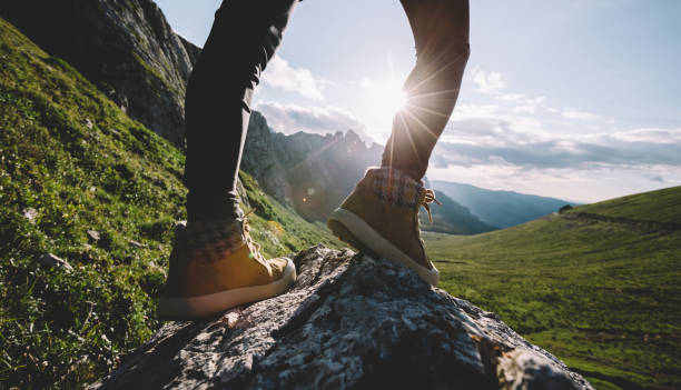 istock Successful woman backpacker hiking on sunset alpine mountain peak 1334563739
