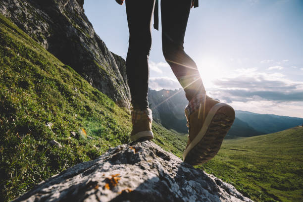 istock Successful woman backpacker hiking on sunset alpine mountain peak 1334563749