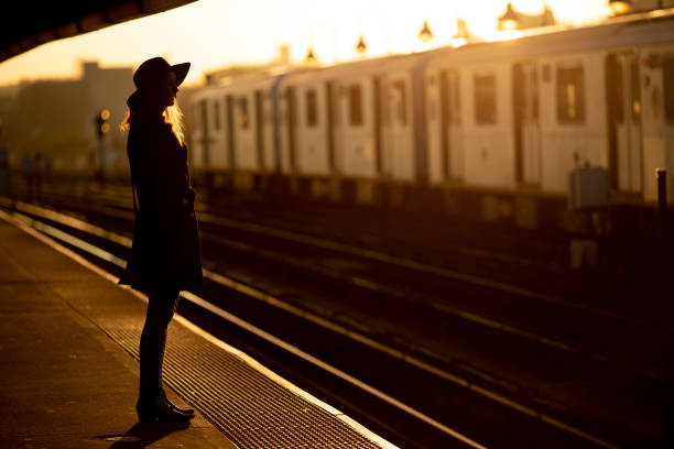 New York City, USA - October 31, 2018: Woman waiting for the train on the subway platform in the morning.