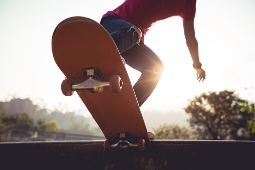 Asian woman skateboarder skateboarding at skatepark