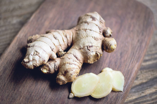 istock Fresh ginger root on cutting board with sliced ginger on wooden background 1334565549
