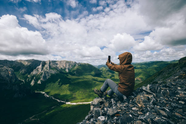 istock Successful woman hiker using smart phone on alpine mountain top 1334566287