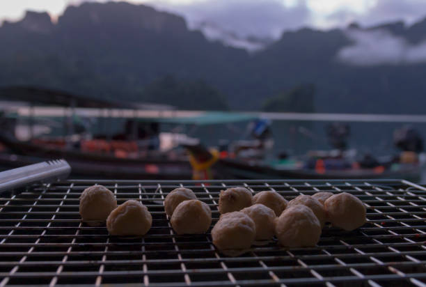 Pork ball placed on a grill, behind the view in Cheow Lan Dam, Thailand stock photo