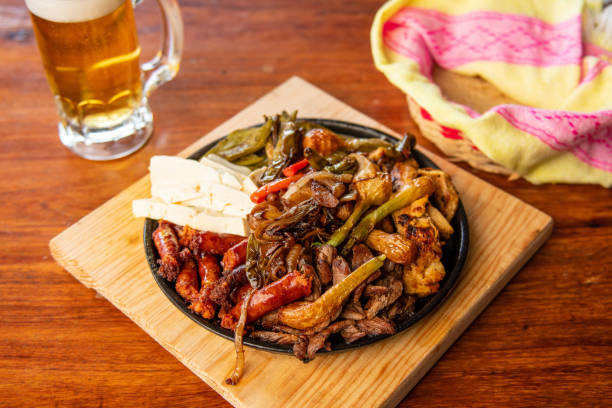 istock Authentic Mexican barbecue, different cuts roasted on a restaurant table. Chistorra, meat and grilled cheeses. Mexican roast beef concept. 1334567101