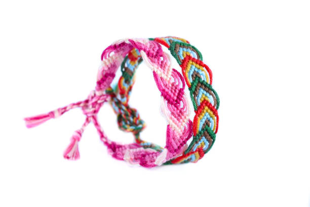 istock Woven friendship bracelet with bright colorful pattern handmade of thread isolated on white background 1334570577