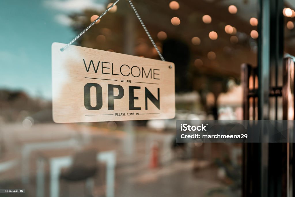 Open cafe or restaurant. Open sign board on glass door in modern cafe coffee shop Small Business Stock Photo