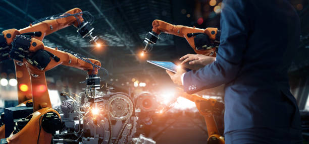 istock Manager engineer check and control automation robot arms machine in intelligent factory industrial on real time monitoring system software. Welding robotics and digital manufacturing operation. 1334575857