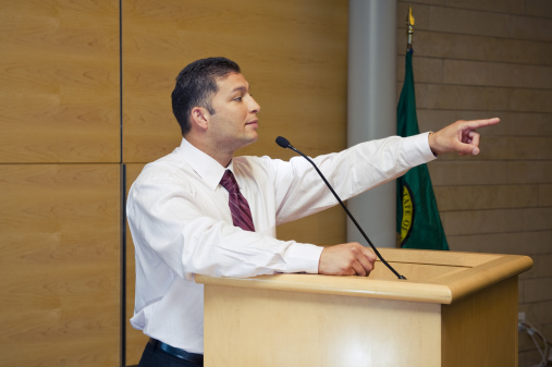 Hispanic businessman pointing a finger at someone.