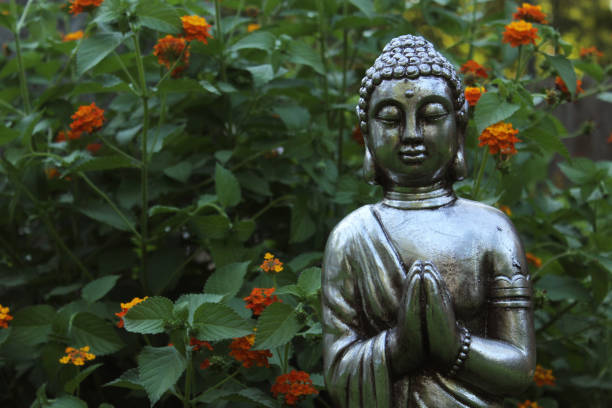 Buddha Statue in Garden with green plants in background