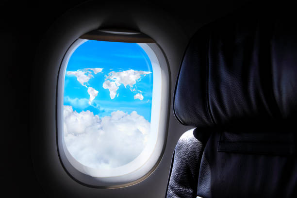 Window of airplane looking towards cloudscape